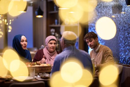 Téléchargez les photos : Une famille islamique européenne moderne et traditionnelle se réunit pour iftar dans un restaurant contemporain pendant la période de jeûne du Ramadan, incarnant l'harmonie culturelle et l'unité familiale au sein d'un - en image libre de droit