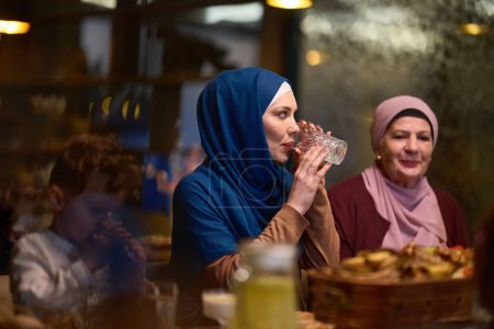 Photo for A modern and traditional European Islamic family comes together for iftar in a contemporary restaurant during the Ramadan fasting period, embodying cultural harmony and familial unity amidst a - Royalty Free Image