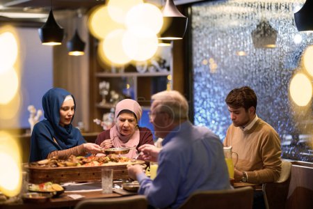 Foto de Una familia islámica europea moderna y tradicional se reúne para iftar en un restaurante contemporáneo durante el período de ayuno del Ramadán, encarnando la armonía cultural y la unidad familiar en medio de un - Imagen libre de derechos