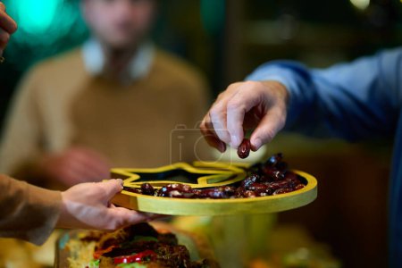 In dieser modernen Darstellung nimmt eine europäisch-islamische Familie an der Tradition teil, ihr Ramadan-Fasten mit Datteln zu brechen, die die Einheit, das kulturelle Erbe und die spirituelle Befolgung des heiligen Tages symbolisieren.