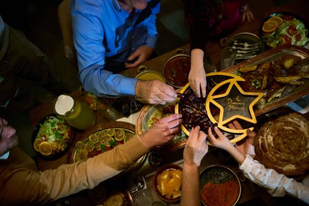 In dieser modernen Darstellung nimmt eine europäisch-islamische Familie an der Tradition teil, ihr Ramadan-Fasten mit Datteln zu brechen, die die Einheit, das kulturelle Erbe und die spirituelle Befolgung des heiligen Tages symbolisieren.