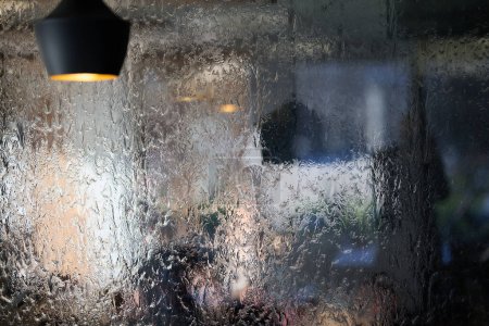 Foto de En una captura de cerca, la textura del vidrio a través del cual fluye el agua se representa maravillosamente, mostrando patrones intrincados y la fluidez del movimiento en una pantalla fascinante. - Imagen libre de derechos