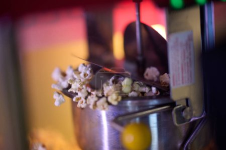 Eine Nahaufnahme fängt den faszinierenden Prozess der Herstellung von Kino-Popcorn ein, bei dem Kerne knallen und ein unwiderstehliches Aroma freisetzen, das einen köstlichen Snack für Kinobesucher verspricht..