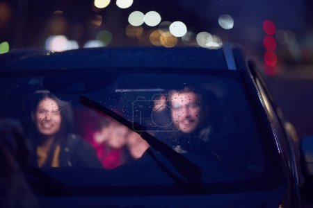Photo for In the nighttime hours, a happy family enjoys playful moments together inside a car as they journey on a nocturnal road trip, illuminated by the glow of headlights and filled with laughter and joy. - Royalty Free Image