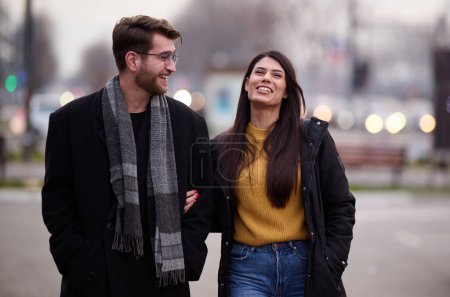 Ein romantisches Paar umarmt sich in einer zarten Umarmung, während sie durch die Straßen der Stadt schlendern und die Freizeit miteinander genießen.