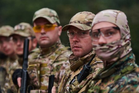Foto de Combatientes soldados de pie junto con armas de fuego. Retrato de grupo de miembros de élite del ejército estadounidense, militares privados, escuadrón antiterrorista. - Imagen libre de derechos