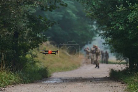 Téléchargez les photos : Unité militaire d'élite défilant et sécurisant la forêt, utilisant des drones pour le balayage du terrain et la reconnaissance, montrant leurs compétences avancées et leur formation spécialisée dans les opérations à haut risque. - en image libre de droit