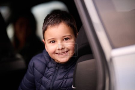 Photo for A young boy enjoys a car ride, captured through the window, as he observes the passing scenery - Royalty Free Image
