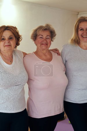 A vibrant community of senior women, guided by their instructor, embraces the enriching journey of yoga, fostering unity, well-being, and a shared commitment to active aging. 
