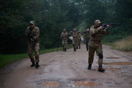 Un groupe de soldats d'élite conduit des prisonniers à travers un camp militaire, montrant une atmosphère tendue de détention et d'opérations de sécurité. 