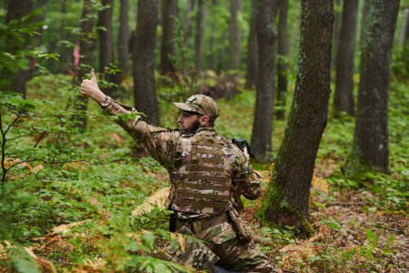 Ein Elitesoldat, der getarnt und heimlich durch gefährliches Waldgebiet navigiert, führt eine verdeckte Mission in einem abgelegenen Waldgebiet aus.. 
