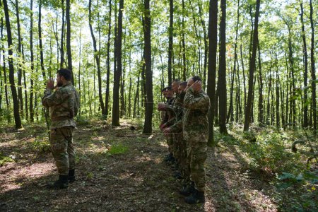 Eine engagierte Gruppe von Soldaten verrichtet inmitten der schwierigen und gefährlichen Bedingungen einer Militäroperation in dicht bewaldeten Gebieten das islamische Gebet. 