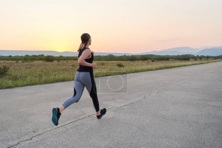Photo for Embodying strength and determination, a lone runner pursues her fitness goals with fervor, gearing up for upcoming marathon challenges while embracing a healthy lifestyle - Royalty Free Image