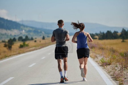 Photo for A vibrant couple dashes running the outdoors, embodying the essence of athleticism and romance, their confident strides reflecting a shared commitment to fitness and preparation for future marathon - Royalty Free Image