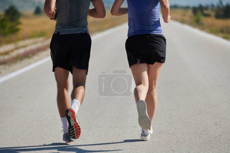 A vibrant couple dashes running the outdoors, embodying the essence of athleticism and romance, their confident strides reflecting a shared commitment to fitness and preparation for future marathon