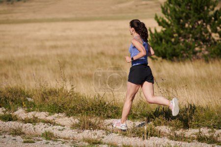 Foto de Encarnando fuerza y determinación, una corredora solitaria persigue sus objetivos de fitness con fervor, preparándose para los próximos desafíos de maratón mientras adopta un estilo de vida saludable - Imagen libre de derechos