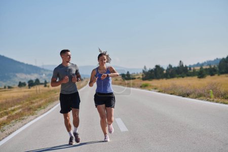 A couple runs through a sun-dappled road, their bodies strong and healthy, their love for each other and the outdoors evident in every stride. 