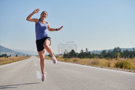 In einer kraftvollen Demonstration von Triumph und Engagement für ihren Sport springt eine Athletin in die Luft und symbolisiert Erfolg und Hingabe auf ihrer Laufreise.