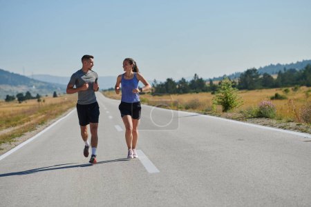 Photo for A couple runs through a sun-dappled road, their bodies strong and healthy, their love for each other and the outdoors evident in every stride. - Royalty Free Image