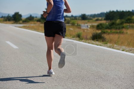 Foto de Encarnando fuerza y determinación, una corredora solitaria persigue sus objetivos de fitness con fervor, preparándose para los próximos desafíos de maratón mientras adopta un estilo de vida saludable - Imagen libre de derechos