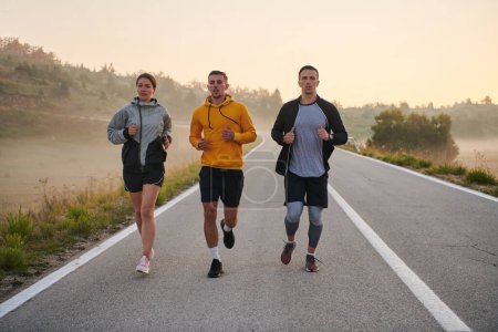 Photo for A group of sports colleagues huddle together for a pre-dawn run, the foggy air and early morning light creating an atmosphere of camaraderie and determination. - Royalty Free Image