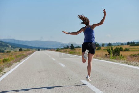 In einer kraftvollen Demonstration von Triumph und Engagement für ihren Sport springt eine Athletin in die Luft und symbolisiert Erfolg und Hingabe auf ihrer Laufreise.