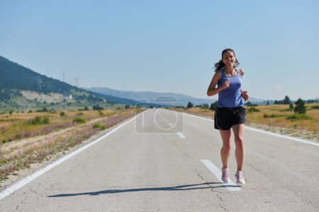 Foto de Una mujer atlética encuentra libertad y alegría en un estilo de vida saludable, corriendo a través de un hermoso sendero al amanecer. - Imagen libre de derechos