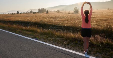  Eine entschlossene, athletische Frau übt sich nach dem Lauf in Stretching, was die Hingabe an ihre Fitness-Reise verkörpert und ihre Beweglichkeit und ihr Wohlbefinden fördert.