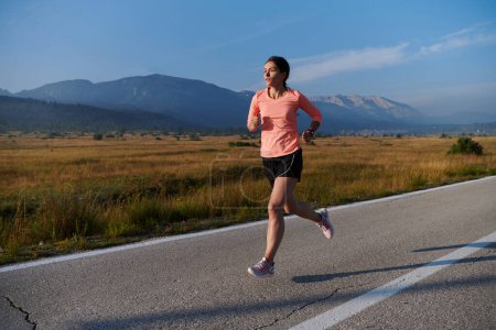 Téléchargez les photos : Une athlète résolue et motivée qui court avec confiance jusqu'au lever du soleil, incarnant la détermination et l'autonomisation dans sa course matinale. - en image libre de droit