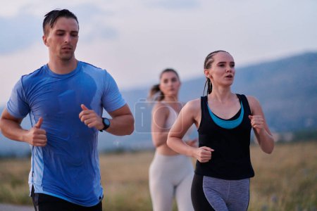 A diverse group of runners finds motivation and inspiration in each other as they train together for an upcoming competition, set against a breathtaking sunset backdrop. 