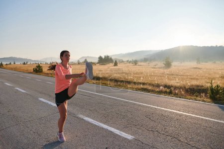 Photo for A determined athletic woman engages in post-run stretching, epitomizing dedication to her fitness journey and nurturing her bodys flexibility and well-being - Royalty Free Image