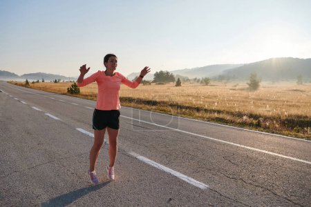 Téléchargez les photos : Une femme athlétique déterminée s'engage dans des étirements post-course, incarnant son dévouement à son voyage de remise en forme et nourrissant son corps flexibilité et bien-être - en image libre de droit