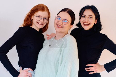 Photo for Familial love and unity as three sisters embrace each other against a pure white backdrop, symbolizing the enduring bond of sisterhood. - Royalty Free Image