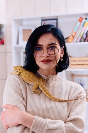 Photo for A young woman poses with her two pets, a bearded dragon and a stick insect, in this heartwarming photo. - Royalty Free Image