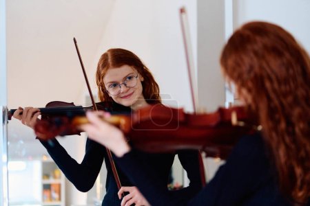 Photo for A stunning redhead musician exudes elegance as she poses with her violin, embodying both grace and musical prowess. - Royalty Free Image