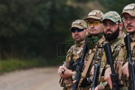 Photo for Soldier fighters standing together with guns. Group portrait of US army elite members, private military company servicemen, anti terrorist squad. - Royalty Free Image