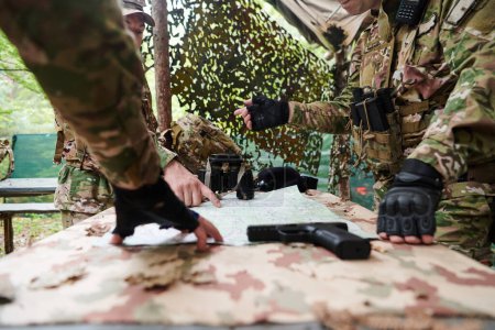 Una unidad militar altamente entrenada planifica y organiza una misión táctica mientras estudia un mapa militar durante una sesión informativa. 