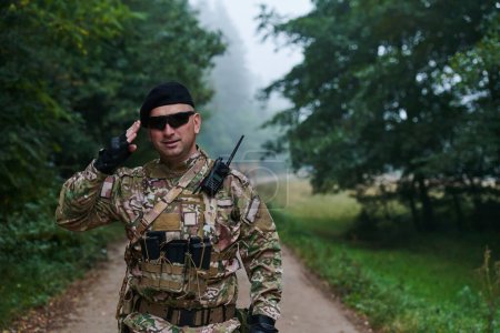 Foto de Un soldado dedicado saluda a su unidad de élite, mostrando camaradería y disposición para las operaciones militares más peligrosas. - Imagen libre de derechos