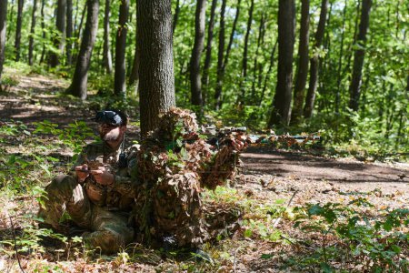 Ein erfahrener Scharfschütze und ein Soldat, der eine Drohne mit VR-Brille bedient, verfolgen die Militäraktion, während sie im Wald versteckt sind. 