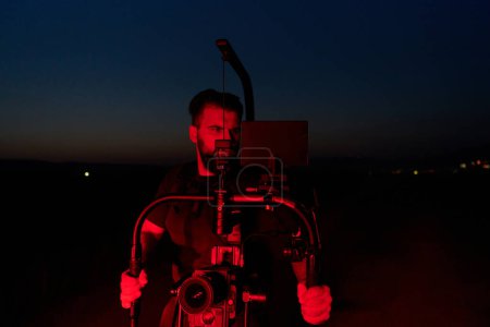 Un experto videógrafo captura la intensidad de los atletas que corren, iluminados por vibrantes luces rojas, encapsulando la energía y la determinación de su sesión de entrenamiento nocturno.