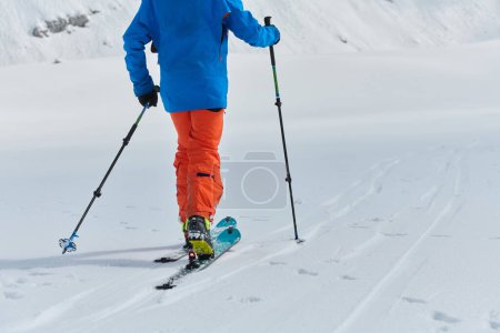 Photo for A lone skier braves the elements on a perilous climb to the top of an alpine peak. - Royalty Free Image