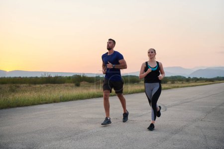 Una pareja vibrante corre al aire libre, encarnando la esencia del atletismo y el romance, sus pasos confiados que reflejan un compromiso compartido con la aptitud y la preparación para la futura maratón