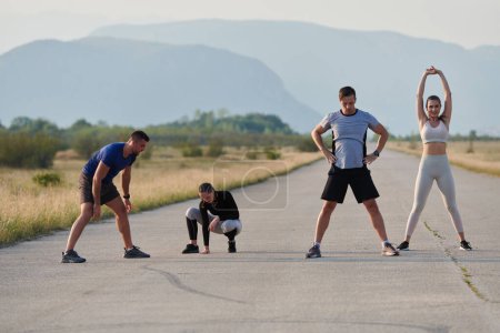 A determined group of athletes engage in a collective stretching session before their run, fostering teamwork and preparation in pursuit of their fitness goals.