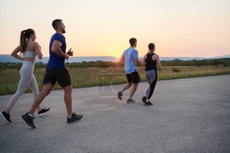 A diverse group of runners finds motivation and inspiration in each other as they train together for an upcoming competition, set against a breathtaking sunset backdrop. 