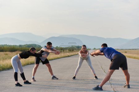 Un groupe déterminé d'athlètes s'engagent dans une séance d'étirement collectif avant leur course, favorisant le travail d'équipe et la préparation à la poursuite de leurs objectifs de conditionnement physique..