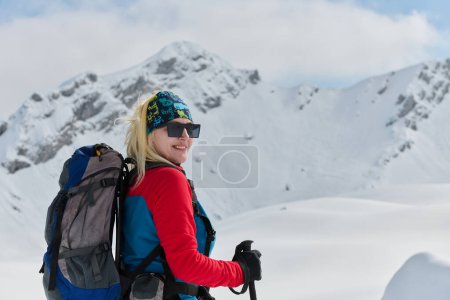 Foto de Un esquiador determinado escala un pico cubierto de nieve en los Alpes, llevando equipo de backcountry para un descenso épico - Imagen libre de derechos