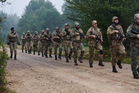 Una unidad militar de élite, dirigida por un mayor, desfila con confianza a través de bosques densos, mostrando precisión, disciplina y preparación para operaciones de alto riesgo. 
