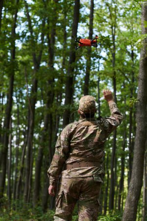 Photo for Elite military unit, equipped with state-of-the-art technology including a drone, strategically navigates and surveys dangerous wooded terrain, showcasing their precision, cooperation, and specialized - Royalty Free Image