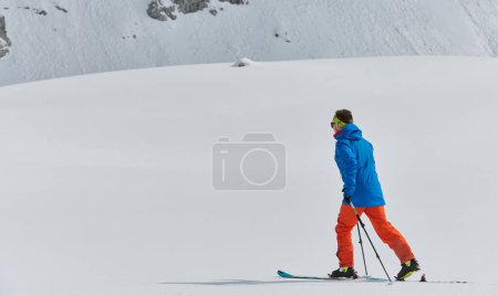 Ein einsamer Skifahrer trotzt den Elementen bei einem gefährlichen Aufstieg auf den Gipfel eines alpinen Gipfels.