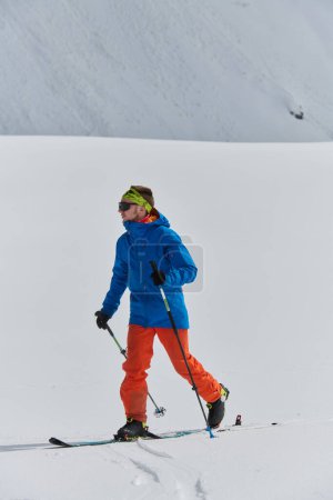 Téléchargez les photos : Un skieur solitaire brave les éléments lors d'une ascension périlleuse jusqu'au sommet d'un pic alpin. - en image libre de droit